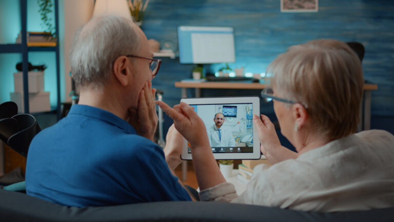 Aged man and woman talking to dentist on online video call