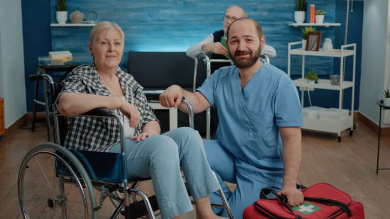 Portrait of senior woman in wheelchair and man nurse
